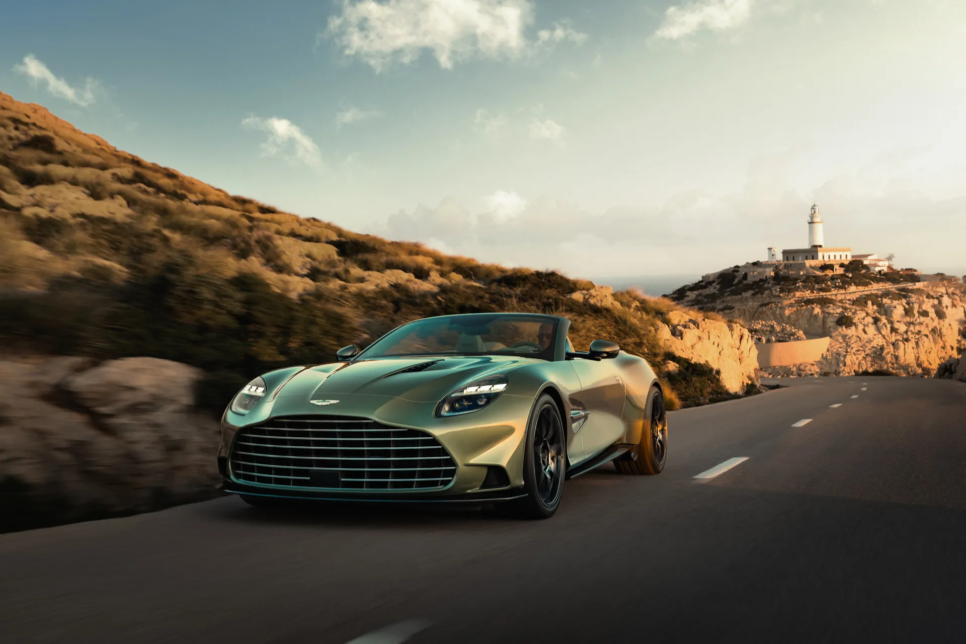 Aston Martin Vanquish Volante в движении по приморской дороге днём, вид спереди