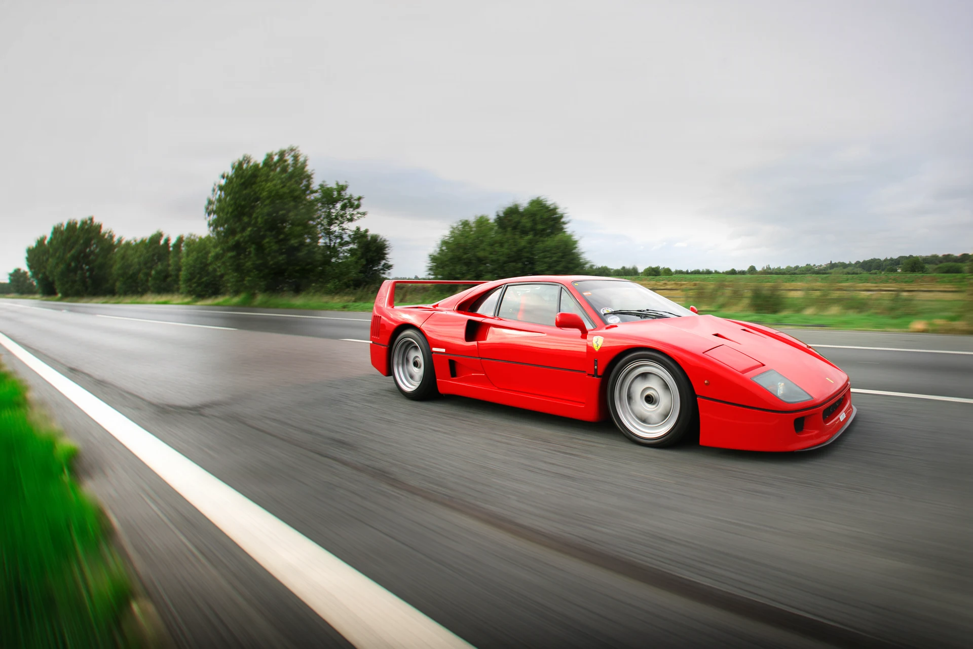 Красный Ferrari F40 в движении по шоссе