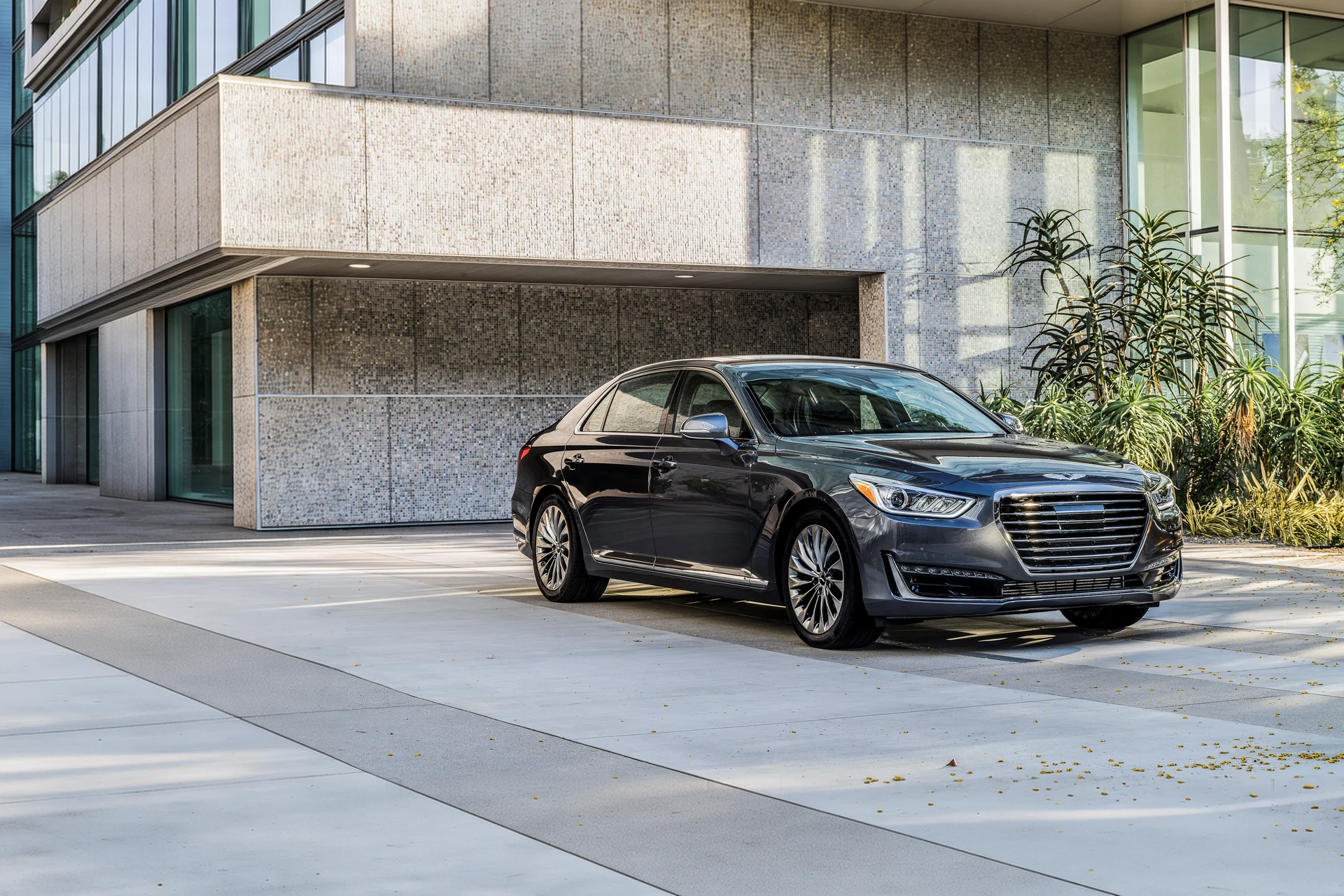 Genesis G90 первого поколения, 2016 год, в три четверти спереди во дворе здания