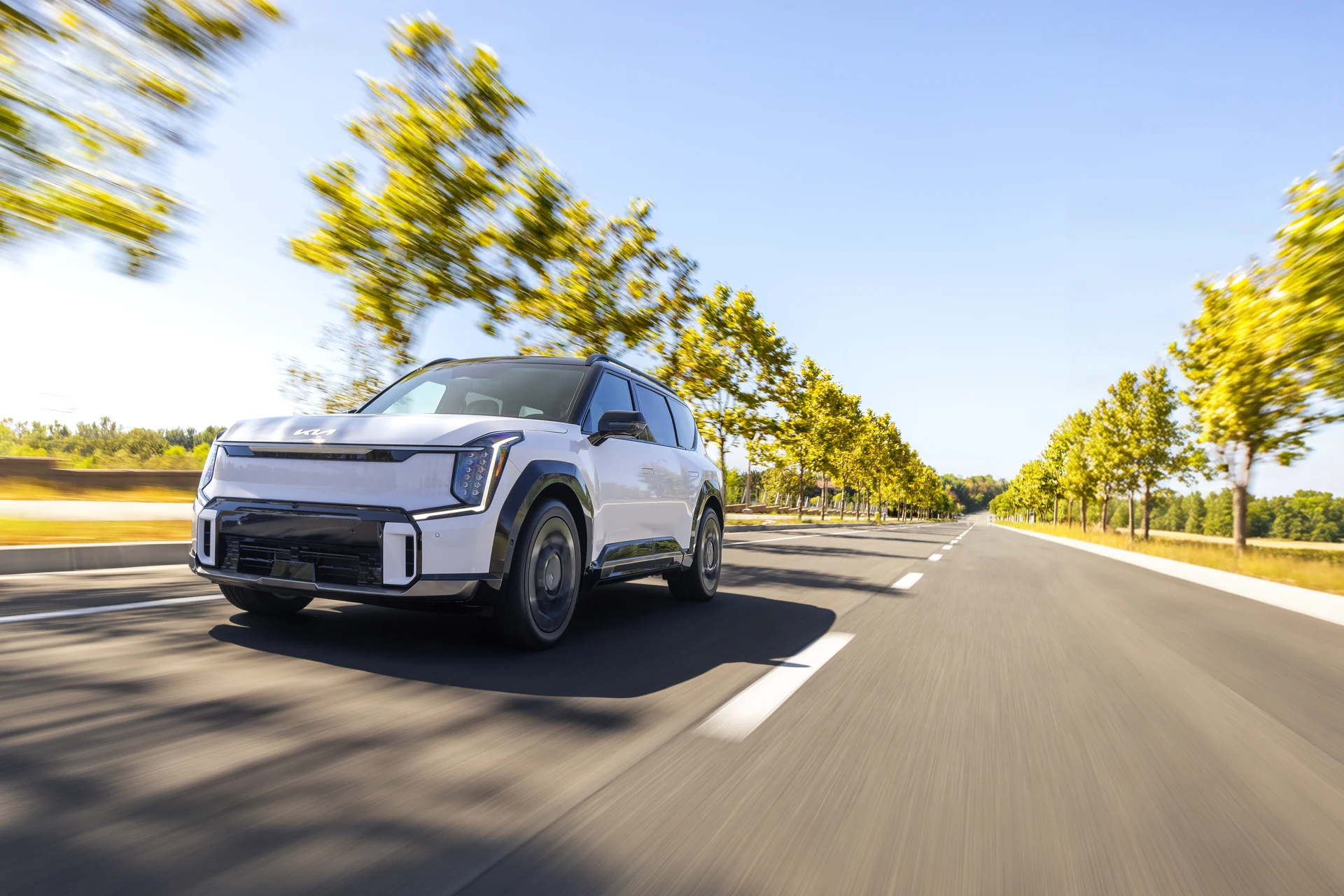 Kia EV9 в движении по аллее