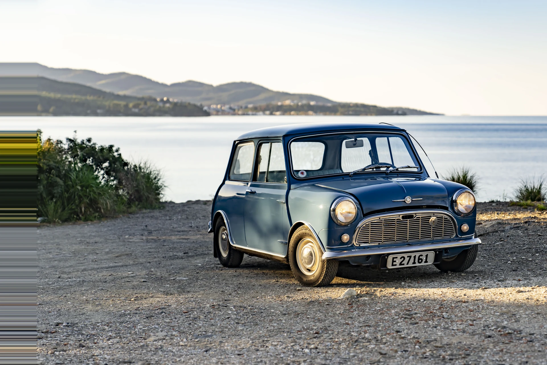 Классический Mini начала 1960-х на берегу моря, в три четверти спереди